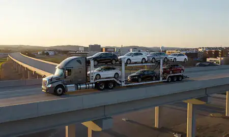Car transporter with the Pierre, South Dakota, United States skyline behind it