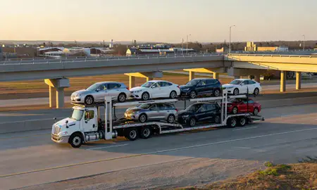 Car transporter with the Collierville, Tennessee, United States skyline behind it