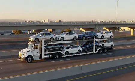 Car transporter with the El Paso, Texas, United States skyline behind it