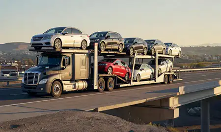 Car transporter with the Bountiful, Utah, United States skyline behind it