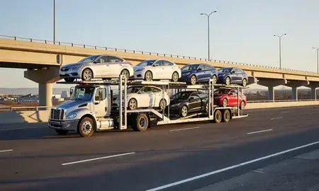 Car transporter with the Draper, Utah, United States skyline behind it
