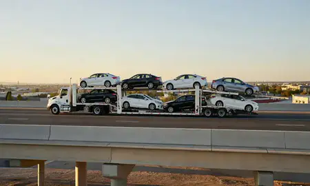 Car transporter with the Taylorsville, Utah, United States skyline behind it