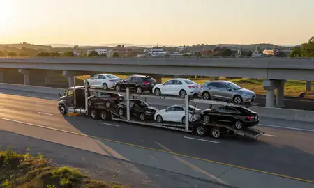 Car transporter with the Barre, Vermont, United States skyline behind it