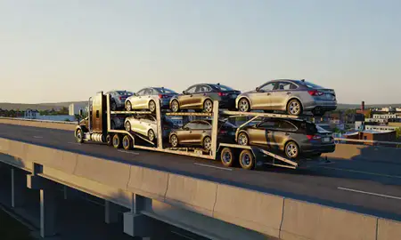 Car transporter with the Winooski, Vermont, United States skyline behind it