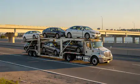 Car transporter with the Portsmouth, Virginia, United States skyline behind it