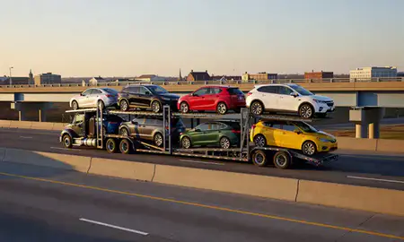 Car transporter with the Williamsburg, Virginia, United States skyline behind it
