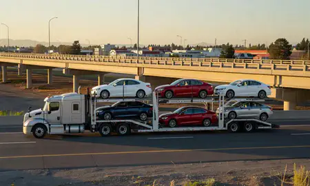 Car transporter with the Lacey, Washington, United States skyline behind it