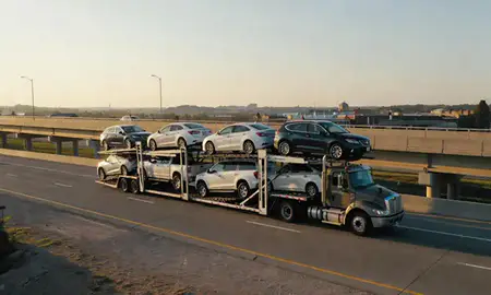 Car transporter with the Moundsville, West Virginia, United States skyline behind it