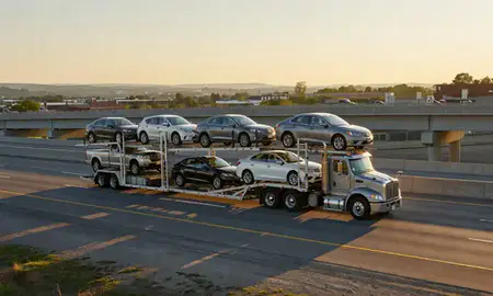 Car transporter with the St. Albans, West Virginia, United States skyline behind it