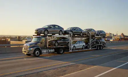 Car transporter with the Appleton, Wisconsin, United States skyline behind it