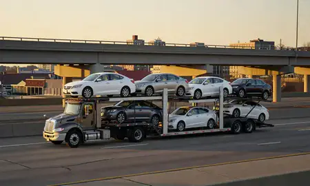 Car transporter with the Fitchburg, Wisconsin, United States skyline behind it