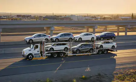 Car transporter with the Fox Farm-College, Wyoming, United States skyline behind it