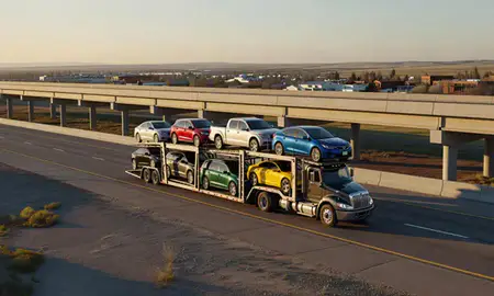 Car transporter with the Glenrock, Wyoming, United States skyline behind it