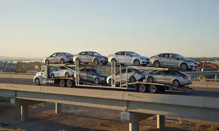 Car transporter with the Thermopolis, Wyoming, United States skyline behind it